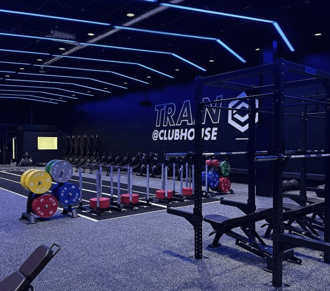 The Clubhouse Blackburn gym from beside the rig, with the sled track and plate stacks along the far wall